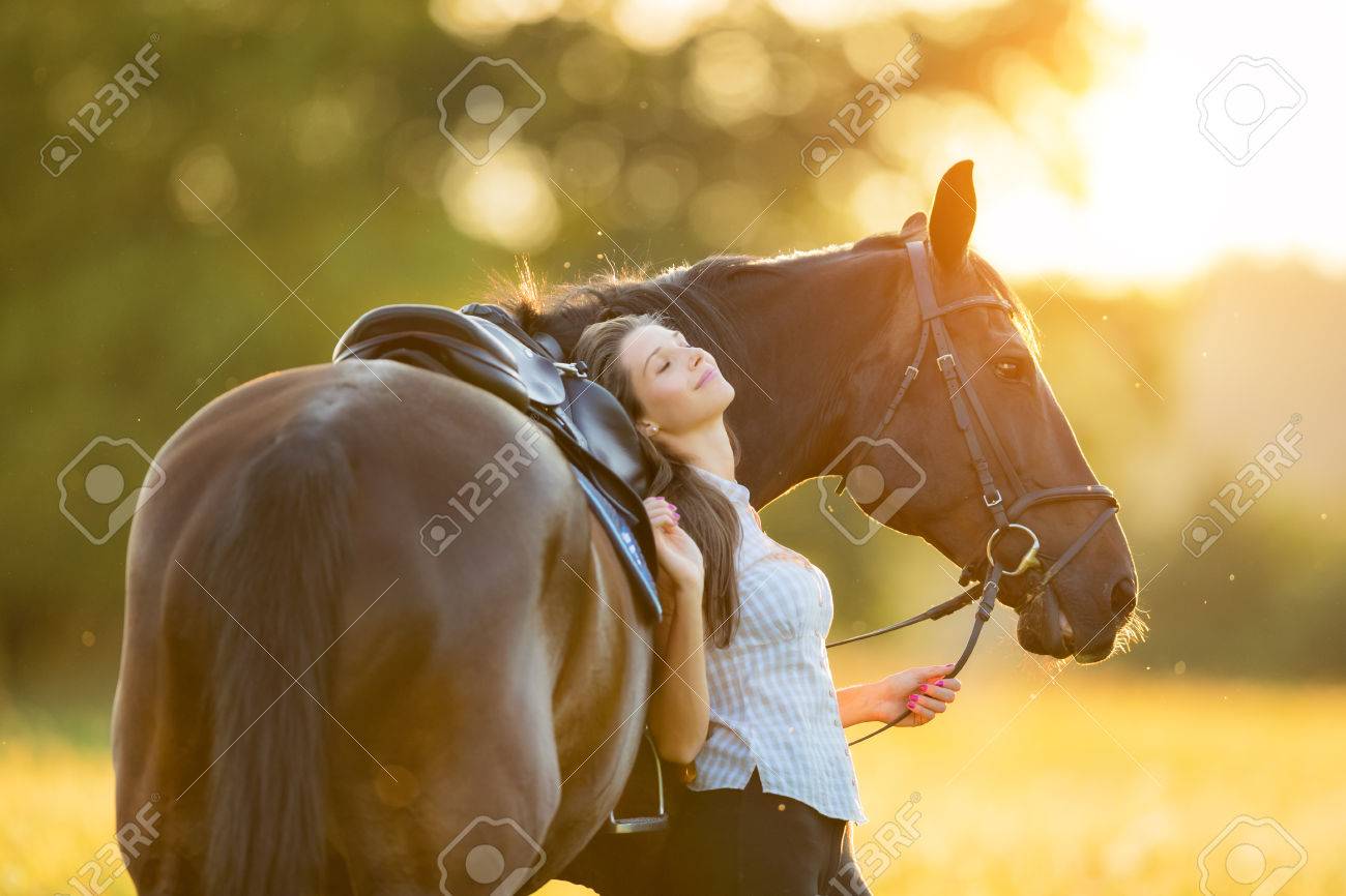 Young woman relaxing with her horse in evening sunset light. Outdoor photography with fashion model girl. - 82699948