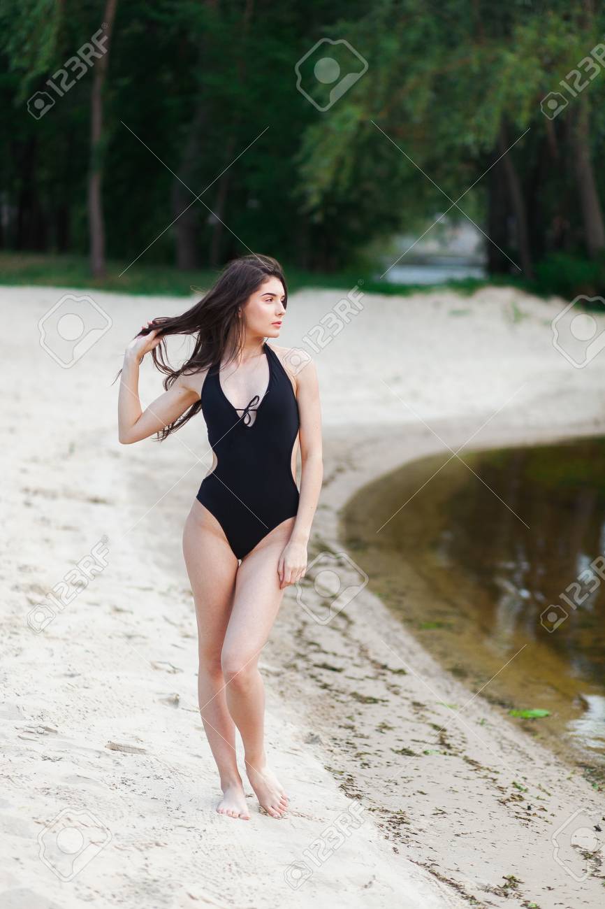 young woman in black swimsuit at the beach - 82814906