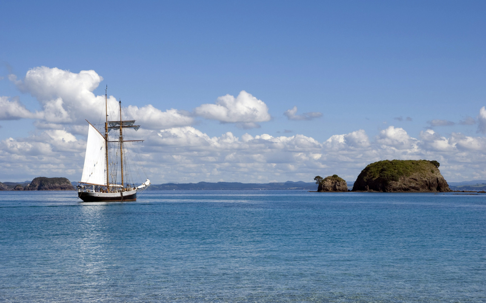 ship, boat, sailing ship, sea, bay, sky, clouds, calm, coast, horizon, island, sailing, cloud, ocean, sailboat, watercraft, islet, sail, loch, tall ship, schooner, windjammer, promontory, inlet, coastal and oceanic landforms